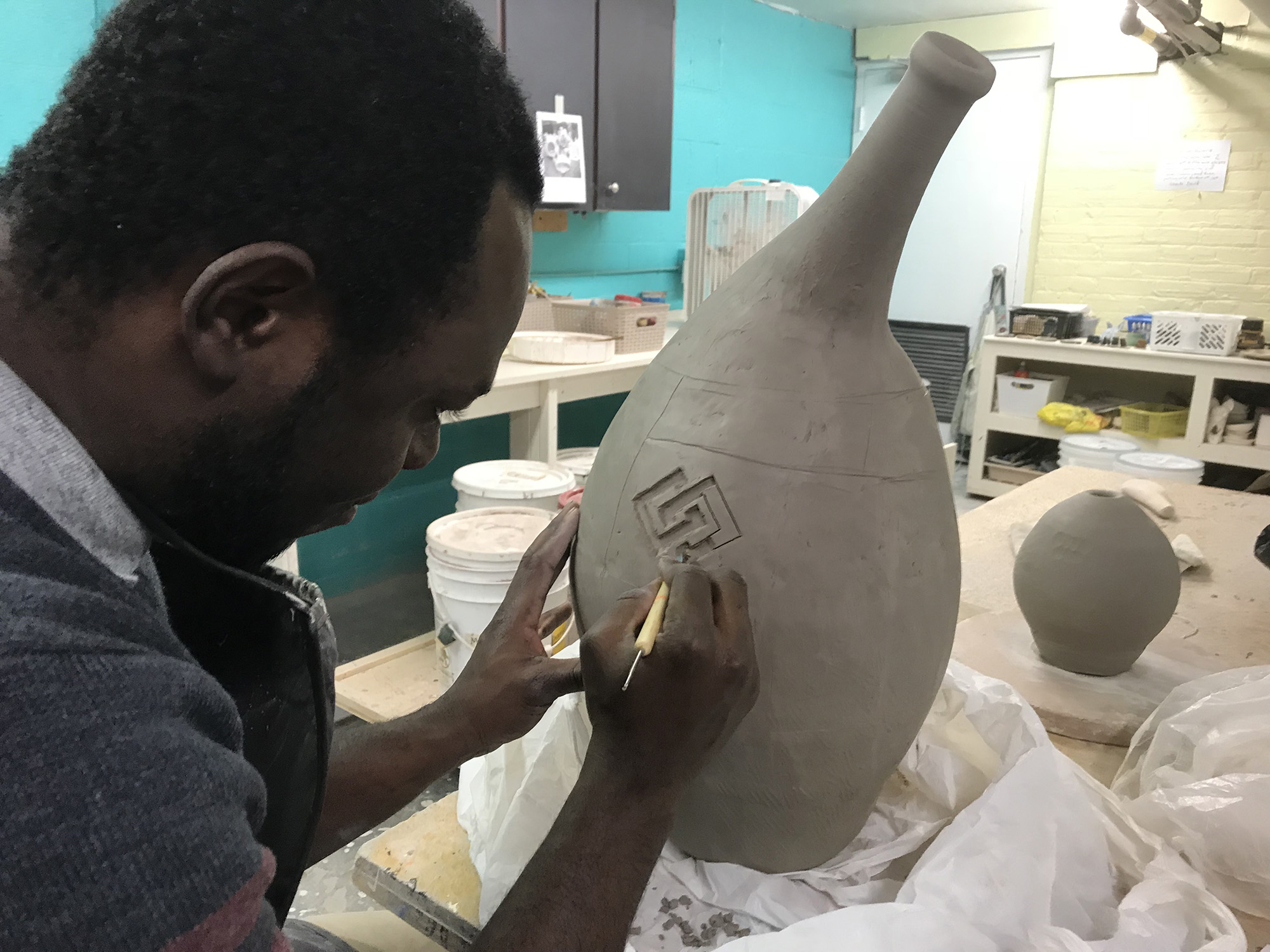 A gentleman working on a pottery piece.